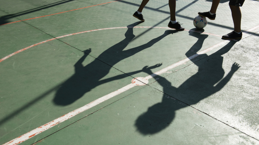 Niños jugando al fútbol en el patio del colegio