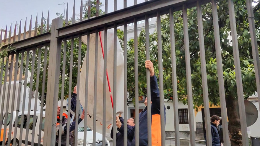 Operarios retiran la pancarta que demandaba la restauración de la Ermita de la Aurora