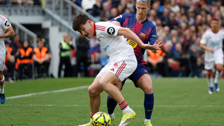 Sevilla's Manu Bueno, left, challenges for the ball with Barcelona's Dani Olmo during the Spanish La Liga soccer match between Barcelona and Sevilla in Barcelona, Spain, Sunday, March 15, 2026. (AP Photo/Joan Monfort)