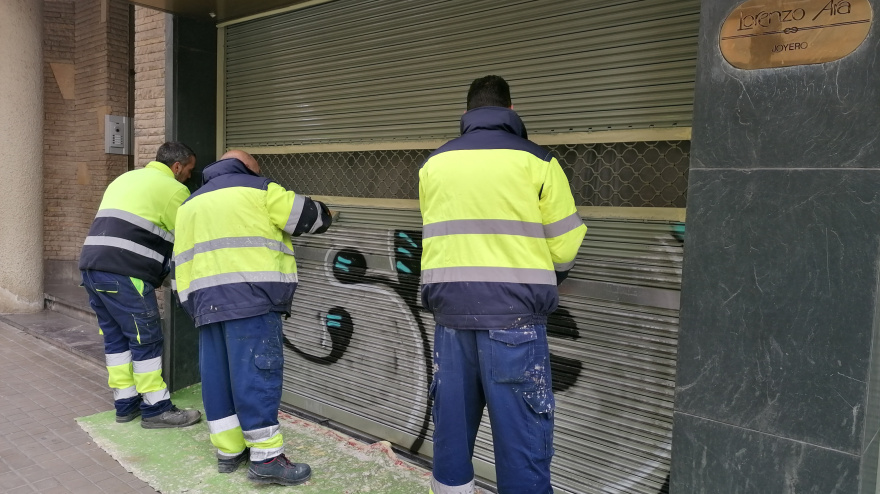 Las brigadas municipales limpiando uno de los grafitis de la ciudad