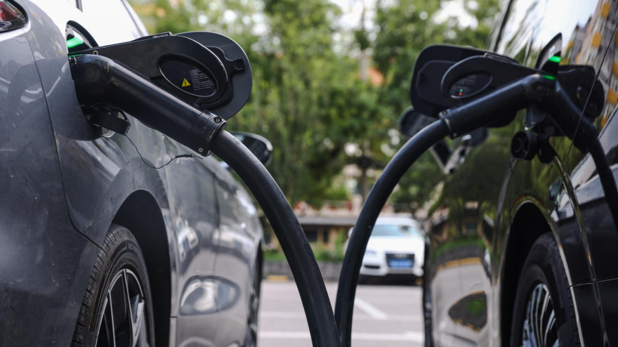 Un coche eléctrico se conecta a un poste de carga para vehículos eléctricos en una estación de carga para vehículos eléctricos.