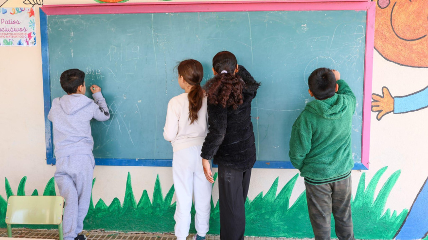 Niños del colegio casa del Niño de Lorca dibujan en una pared del patio durante el recreo