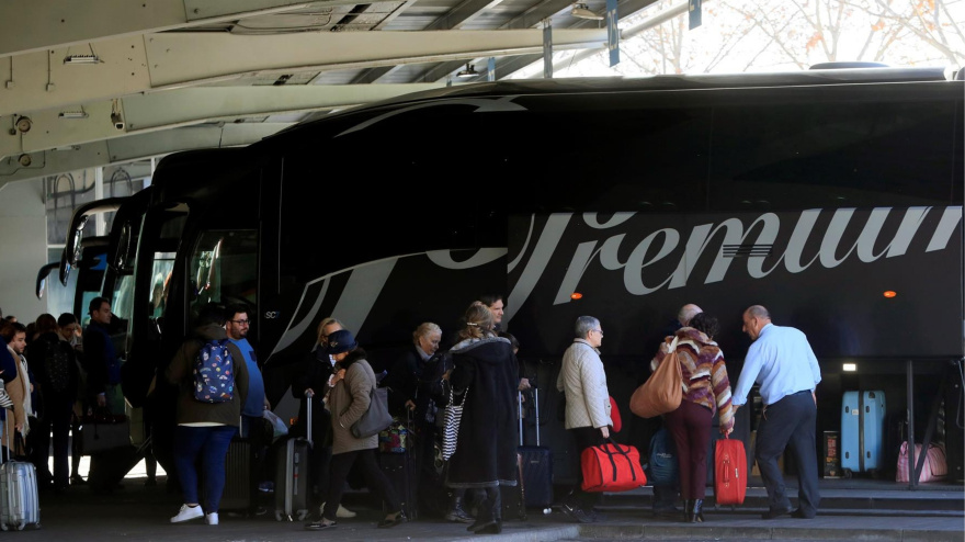 Varios viajeros esperan para poder acceder a un autobús, en la estación de Méndez Álvaro de Madrid