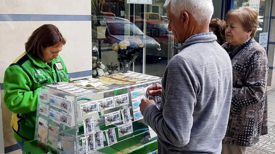 Una vendedora de la ONCE atendiendo a unos clientes