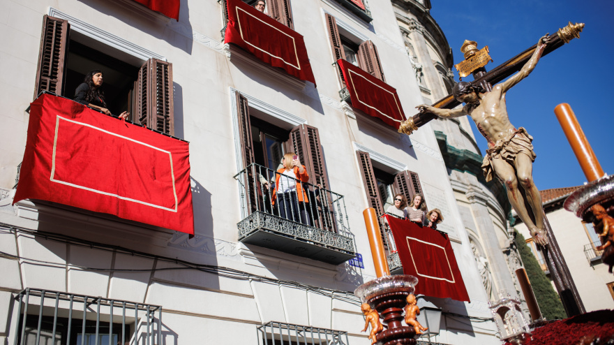Varias personas ven el paso del Santísimo Cristo de la Fe y del Perdón desde los balcones en la procesión de ‘Los Estudiantes’, a 2 de abril de 2023, en Madrid (España).