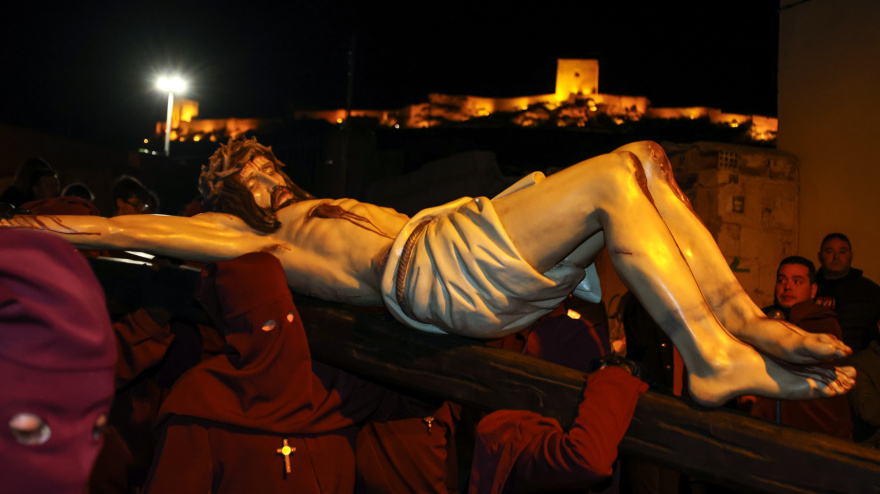 Imagen del traslado del Cristo de la Misericordia por el Calvario, con el castillo de Lorca al fondo