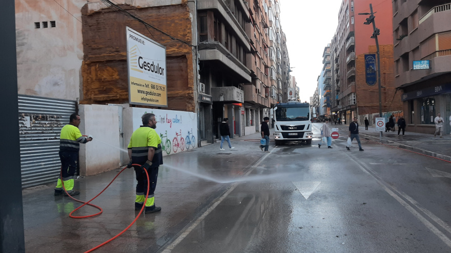 Operarios limpian con agua a presión la avenida Juan Carlos I tras la retirada de los palcos