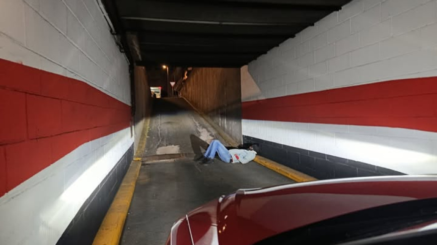 Imagen del individuo inconsciente en la rampa de salida del parking de La Rosa en Santiago
