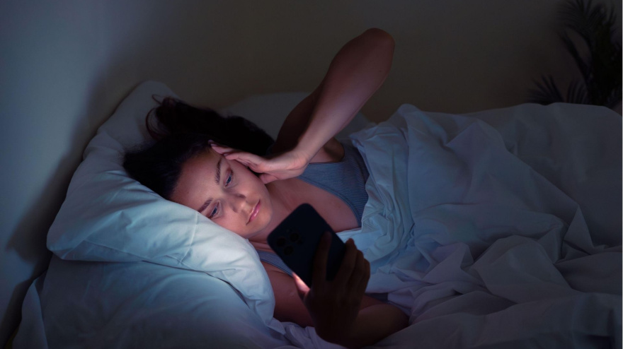 Una mujer se despierta y mira el móvil