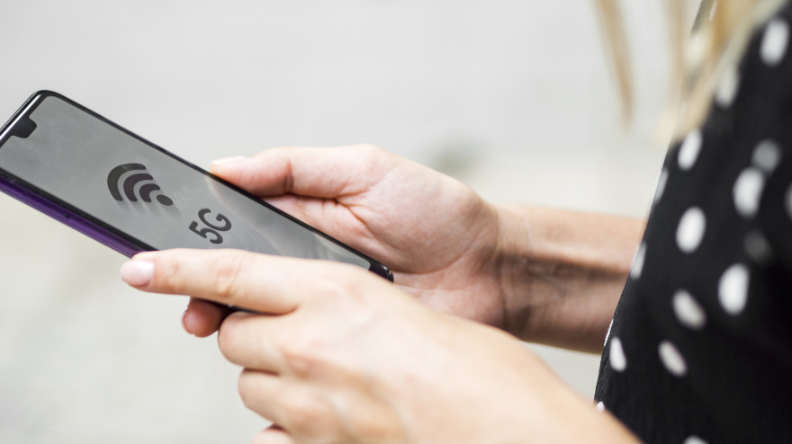 Una mujer observa un móvil en una zona con red 5G
