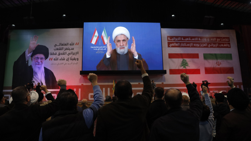 Partidarios de Hezbolá levantan los puños en señal de saludo al secretario general del grupo, el jeque Naim Qassem.