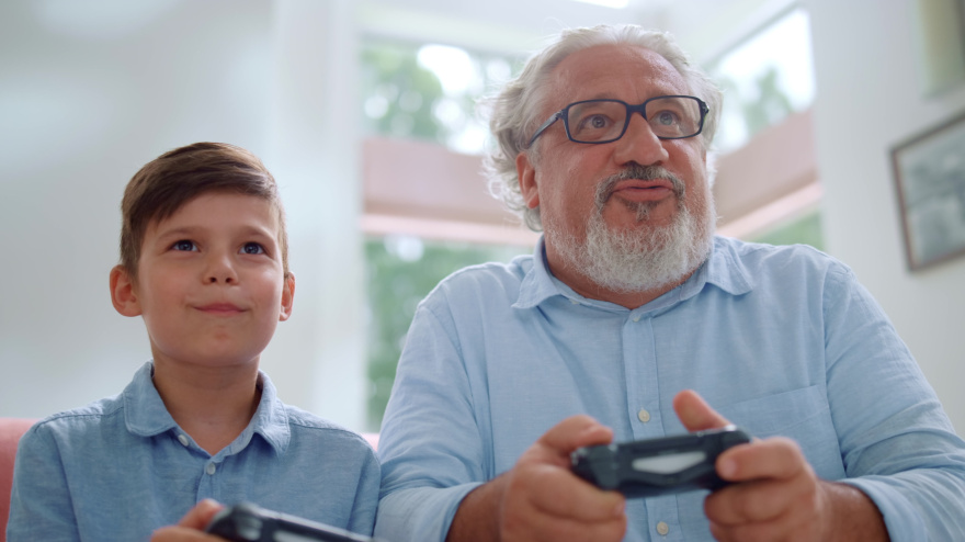 Abuelo y nieto juegan juntos a los videojuegos.