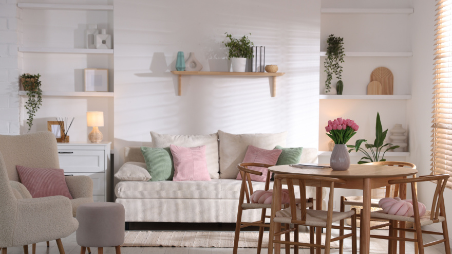 Stylish dining table with chairs and comfortable sofa in room. Interior design