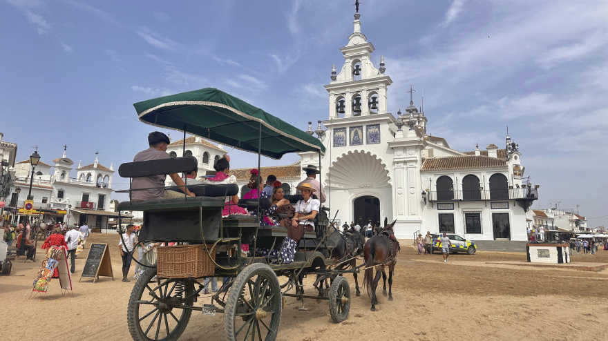 Varias personas visitan a la Virgen del Rocío antes de que salga a recorrer las calles de la aldea, imagen de archivo