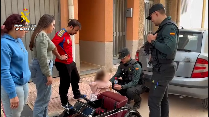 Los agentes de la Guardia civil con la bebé a la que salvaron y sus familiares