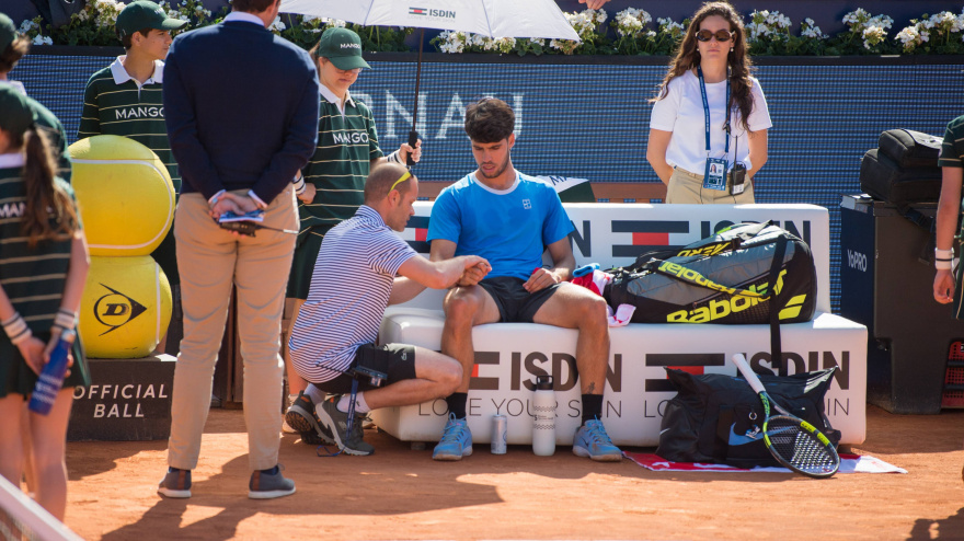 Carlos Alcaraz, recibiendo asistencia médica en el Godó