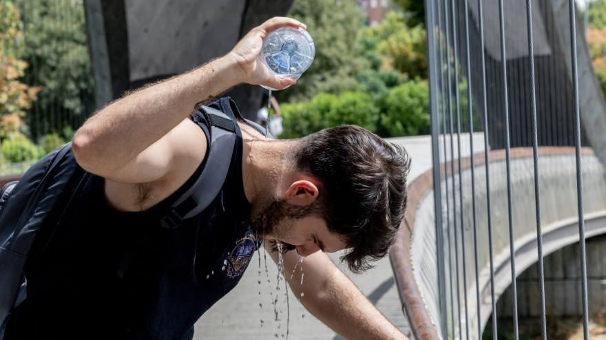 Un chico se moja la cabeza en Madrid por una ola de calor de verano