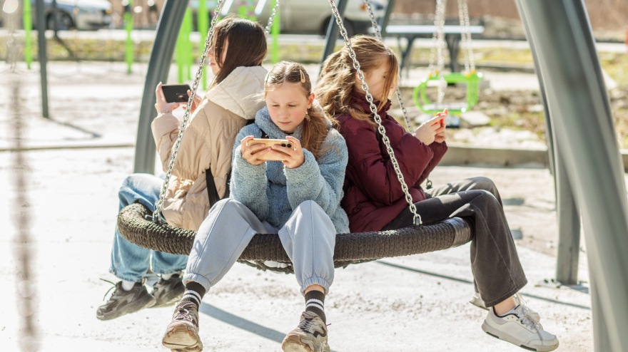 Niñas en un parque con su teléfono móvil