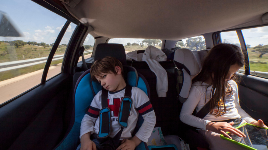Niño de 5 años enfadado dentro del coche. Ha sido castigado quitándole la tableta.