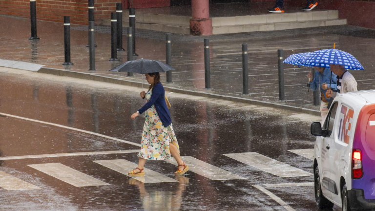 Varias personas se protegen de la lluvia a primera hora en Teruel