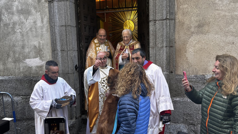 Párroco bendiciendo a un perro