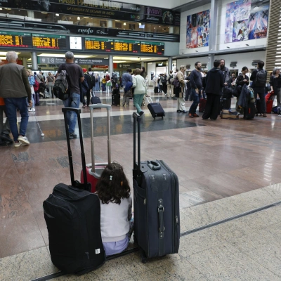 Una niña aguarda junto al equipaje de su familia en la Estación María Zambrano de Málaga