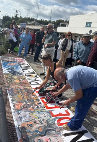 Los artistas elaborando la pancarta