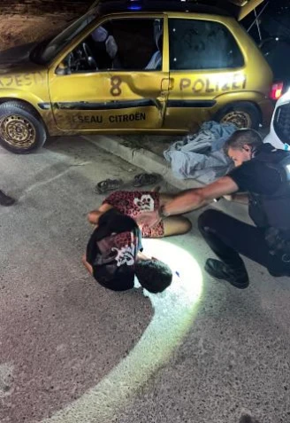 El detenido aparece esposado en el suelo después de la detención.