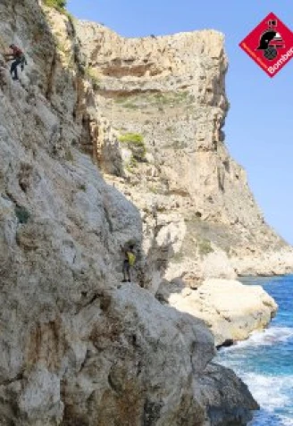 Una moto de agua de Salvamento Marítimo evacuando al hombre rescatado desde la zona plana junto al mar tras ser asegurado y descendido desde el acantilado.