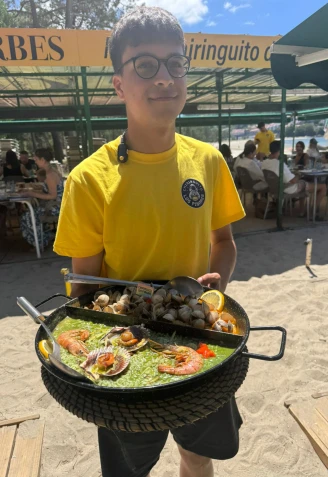 Un camarero con una de las paellas de Los Pinares