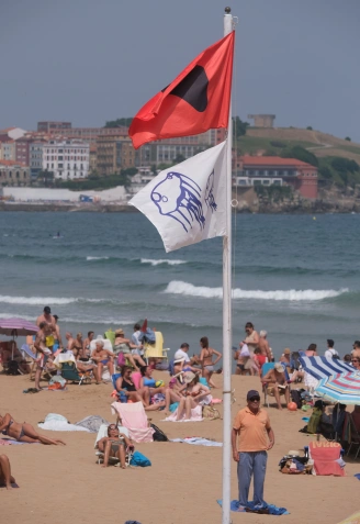 Bandera roja en la playa de San Lorenzo de Gijón por presencia de carabelas portuguesas