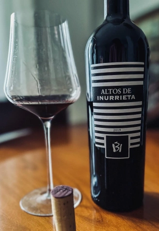 Botella y copa de vino de Altos de Inurrieta Reserva