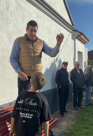 Ángel Ramón Arenas dialoga con un joven del pueblo durante un momento de la rifa.