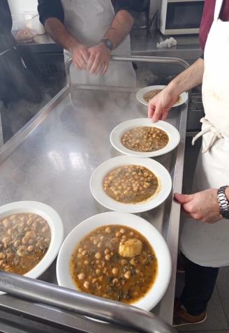 Varios platos de garbanzos con bacalao en el carrito para salir al comedor