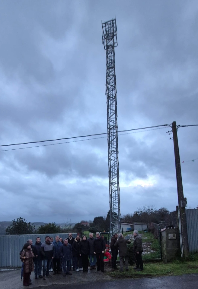Un grupo de vecinos de Aríns protesta bajo la enorme estructura de la antena de más de 30 metros