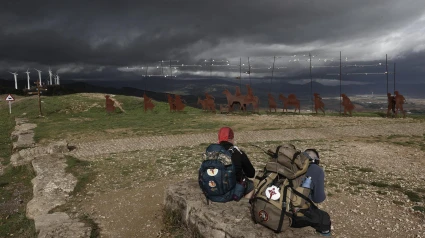 Dos hombres consultan el móvil con una tormenta a punto de empezar.