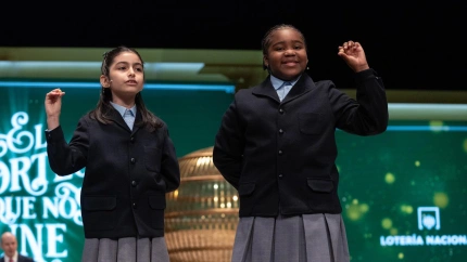 Rosario Martínez Garía (i), y Ainhoa Rosero Gómez (d) cantan un cuarto premio, el número 41147, durante el Sorteo Extraordinario de la Lotería de Navidad 2023 en el Teatro Real de Madrid