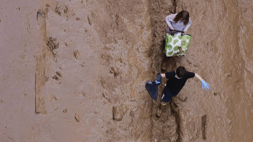 Dos niños que cruzan una calle enfangada de Masanasa