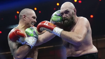 Oleksandr Usyk, calzón morado, golpea a Tyson Fury, calzón rojo, durante la pelea.