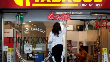 GRAF8456. MADRID, 12/01/2022.- Una mujer limpia el escaparate de su estanco en Madrid, imagen de archivo