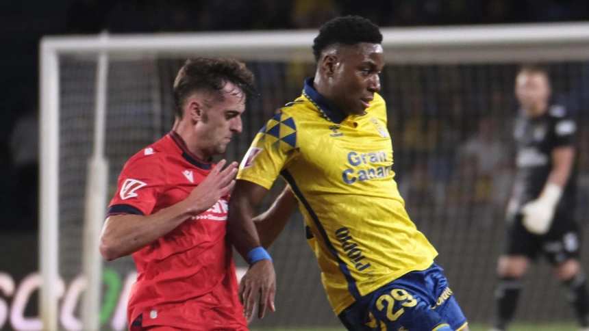 Essugo disputa un balón ante la presión de Aimar Oroz en partido entre Las Palmas y Osasuna.