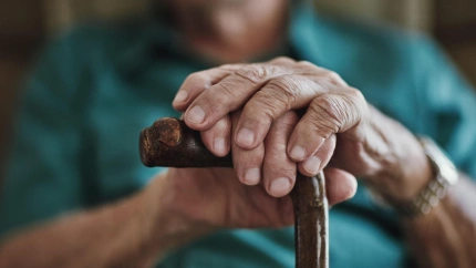 Hombre mayor reposando sus manos sobre un bastón