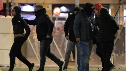 La Ertzaintza se lleva a un joven detenido durante los incidentes entre hinchas del Athletic y el Rangers.