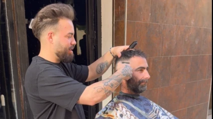 Un peluquero de Lorca, atiende a sus clientes en plena calle de Lorca