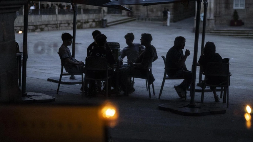 Varias personas en la terraza de un bar al caer la noche durante el apagón eléctrico en Ourense. EFE/ Brais Lorenzo