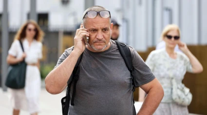 Un hombre muestra preocupación mientras llama por teléfono