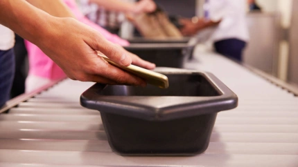 Un hombre pasa su teléfono móvil por el control de seguridad de un aeropuerto