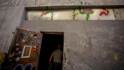 Una persona entra por la puerta del local okupado