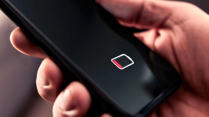 Un teléfono móvil con el símbolo de batería baja iluminado en la pantalla