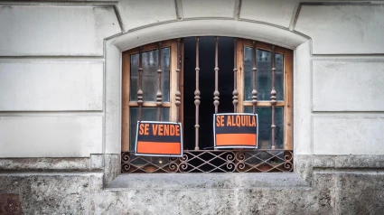 Carteles de 'se vende' y 'se alquila' en la ventana de un piso de Valencia